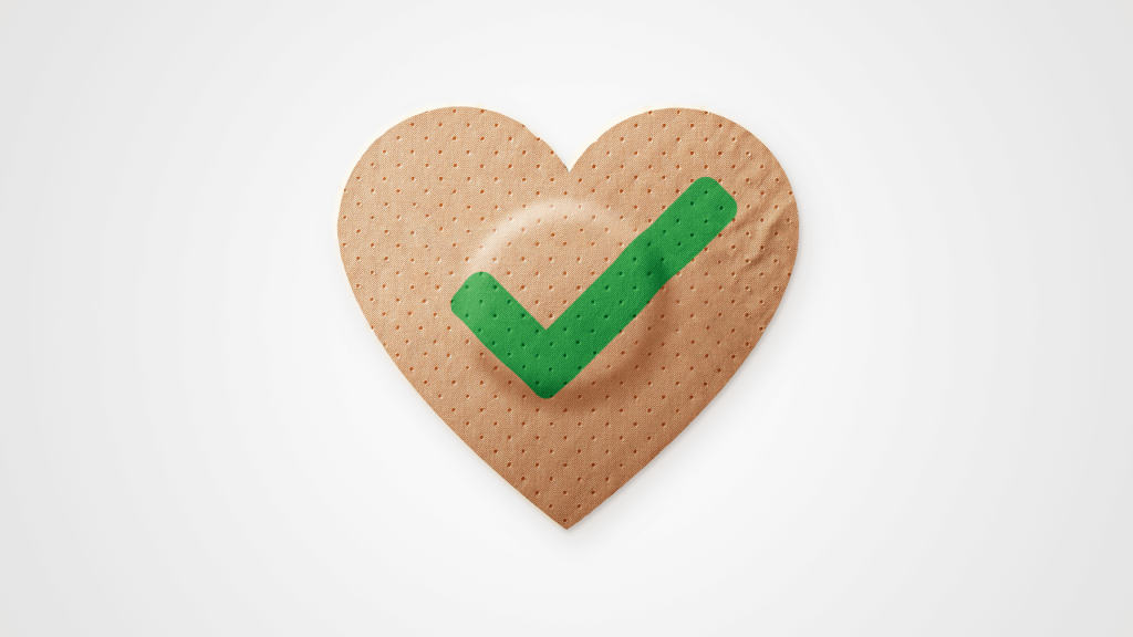 Ein herzf&ouml;rmiger Pflasterverband mit einem gr&uuml;nen H&auml;kchen in der Mitte, das COVID-19 Impfen symbolisiert, auf wei&szlig;em Hintergrund.