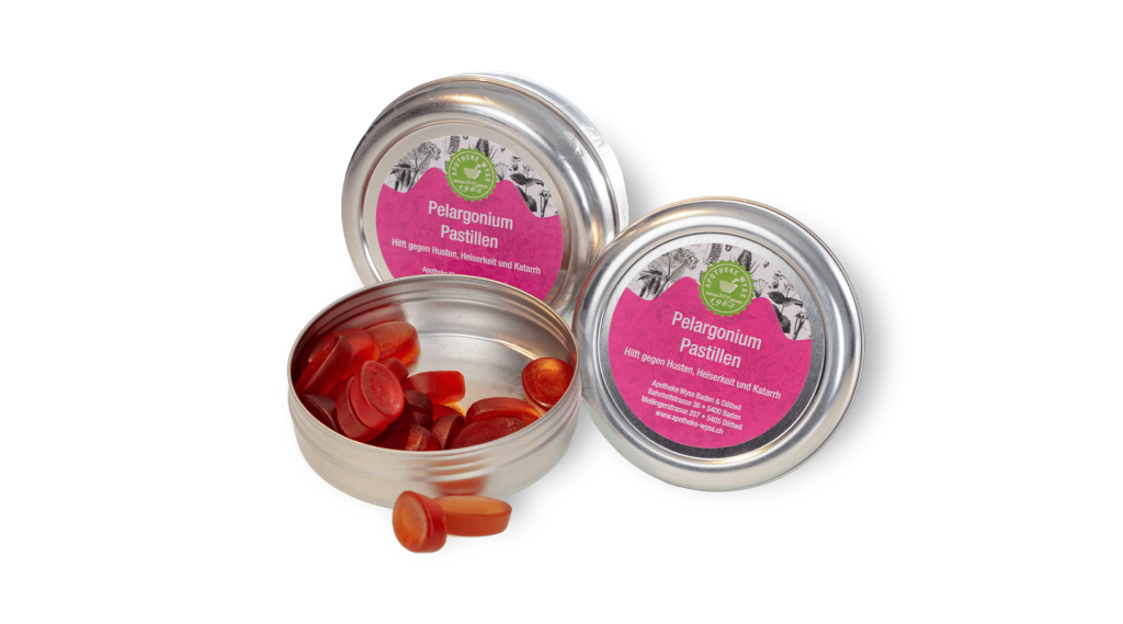 Drei runde Metalldosen, zwei offene und eine geschlossene, mit roten ovalen Pastillen. Die Dosen haben rosa Etiketten mit gr&uuml;nem Logo und der Aufschrift Pelargonium Pastillen.