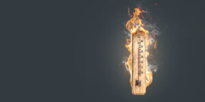 Ein h&ouml;lzernes Thermometer, das &uuml;ber 30 Grad Celsius anzeigt, ist in leuchtend orangefarbene Flammen und Rauch geh&uuml;llt und steht vor einem dunkelgrauen Hintergrund - perfekt, um das Leiden bei extremer Hitze darzustellen.