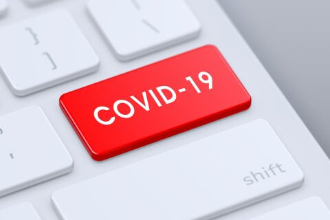 Eine Computertastatur mit einer auff&auml;lligen roten COVID-19-Taste, die eine der Standardtasten ersetzt und neben der wei&szlig;en Umschalttaste liegt.