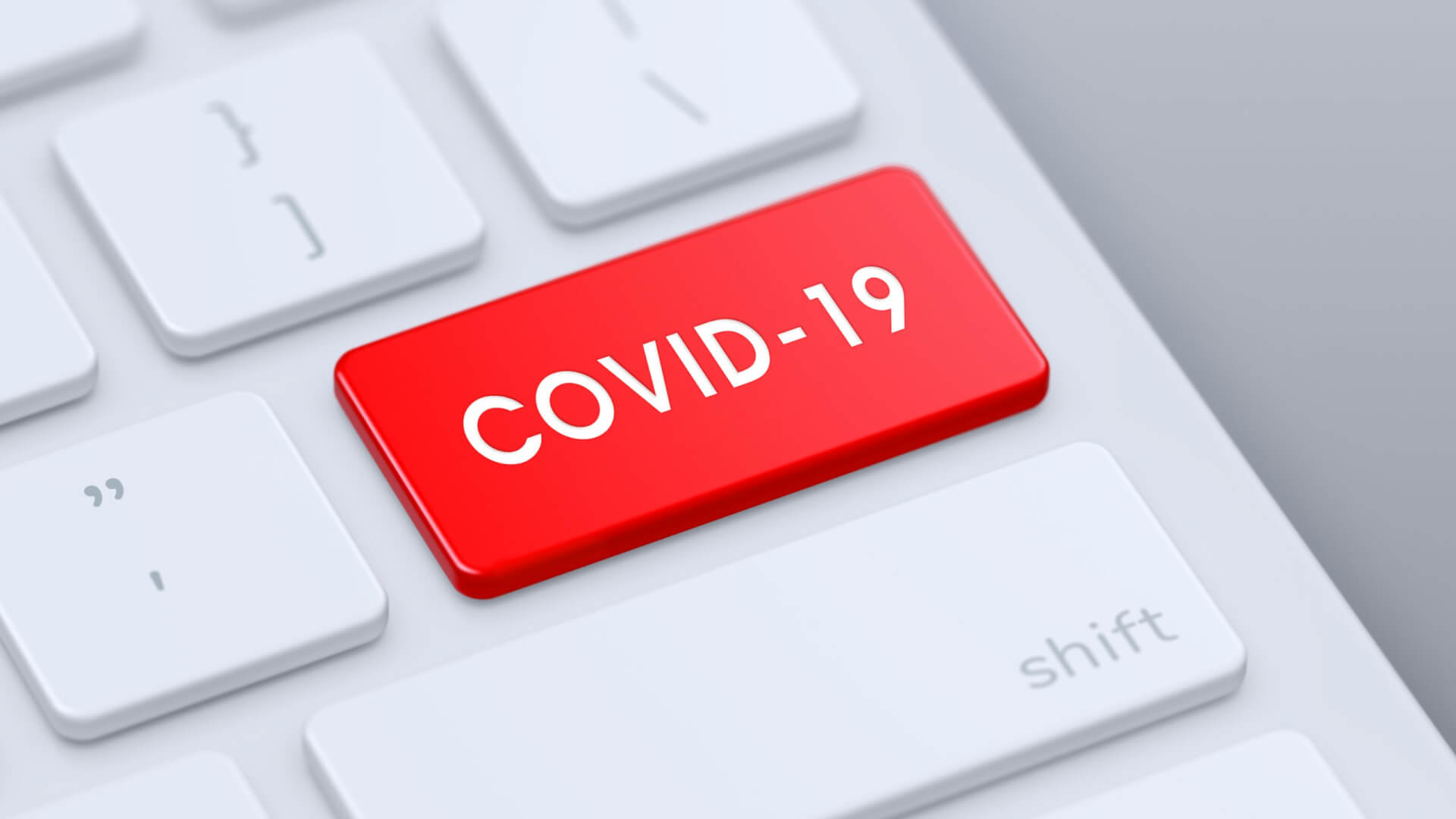 Eine Computertastatur mit einer auff&auml;lligen roten COVID-19-Taste, die eine der Standardtasten ersetzt und neben der wei&szlig;en Umschalttaste liegt.