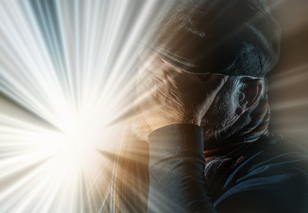 Portrait of an older man who is blinded by a bright light