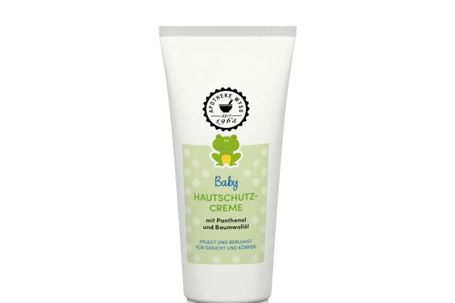 Eine wei&szlig;e Tube mit Hautschutzcreme f&uuml;r Babys, versehen mit einem gr&uuml;nen Etikett, auf dem ein Teddyb&auml;r abgebildet ist und ein deutscher Text steht. Das Produkt tr&auml;gt die Bezeichnung &bdquo;Hautschutzcreme&ldquo; und enth&auml;lt Panthenol und Kamille.